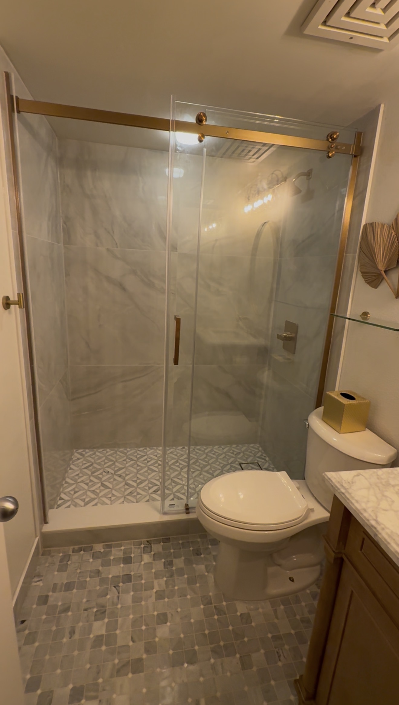 Finished custom bathroom with glass and gold hardware